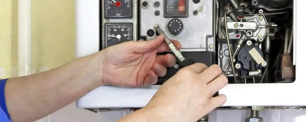 Heating repair technician adjusting boiler controls and components in Greenville, NC